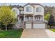 Two-story home with a double garage, covered porch, and well-maintained front lawn at 7141 Red Mesa Dr, Littleton, CO 80125
