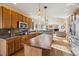 Spacious kitchen with wooden cabinetry, stainless steel appliances, and a large island at 7141 Red Mesa Dr, Littleton, CO 80125