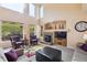 Open-concept living room featuring a fireplace, large windows, and abundant natural light at 7141 Red Mesa Dr, Littleton, CO 80125