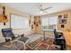 Spacious office with a ceiling fan, desk and chair with an expansive window view at 7141 Red Mesa Dr, Littleton, CO 80125