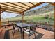 Outdoor deck features a table and chairs, overhead awning, and views of the hillside at 7141 Red Mesa Dr, Littleton, CO 80125