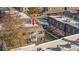 Aerial view of apartment complex showing roof and porch area with tennis court and greenery at 1496 S Pierson St # 116, Denver, CO 80232