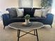 Bright living room featuring a modern sofa with stylish pillows and a unique accent table at 1496 S Pierson St # 116, Denver, CO 80232