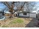 Large backyard featuring mature trees, swing set, and ample space for outdoor activities at 1973 Alton St, Aurora, CO 80010