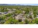 Breathtaking aerial view captures a neighborhood surrounded by mature trees and rolling mountains in the distance at 6025 Johnson Way, Arvada, CO 80004