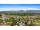 Scenic aerial view showcasing the neighborhood, mountains, and a nearby park with baseball fields on a sunny day at 6025 Johnson Way, Arvada, CO 80004