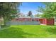 A grassy backyard featuring privacy fence and storage shed at 6025 Johnson Way, Arvada, CO 80004