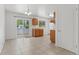 Bright kitchen and dining area with tile floors, wood cabinets, sliding glass doors to the backyard, and a modern chandelier at 6025 Johnson Way, Arvada, CO 80004