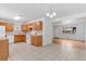 Inviting kitchen with tile floors, wood cabinets, and modern lighting, seamlessly connecting to a bright living space at 6025 Johnson Way, Arvada, CO 80004