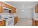 Bright kitchen features tile flooring, wooden cabinets and white appliances at 6025 Johnson Way, Arvada, CO 80004
