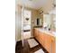 Bright bathroom with a double sink vanity, black tile flooring, and views into the bedroom at 2940 Ulster St, Denver, CO 80238