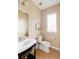 Powder room features a pedestal sink with a black vanity and tile flooring at 2940 Ulster St, Denver, CO 80238