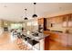 Well-equipped kitchen with an island, granite countertops, wood cabinetry, and stainless appliances at 2940 Ulster St, Denver, CO 80238