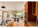 Spacious kitchen offering an island, granite countertops, wood cabinets, and stainless appliances overlooking the living area at 2940 Ulster St, Denver, CO 80238