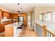 Stylish kitchen featuring wood cabinetry, granite countertops, stainless steel appliances, and a breakfast bar at 2940 Ulster St, Denver, CO 80238