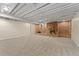 Spacious basement features a brick fireplace, carpeted flooring and exposed beam ceiling at 2692 S Pennsylvania St, Denver, CO 80210
