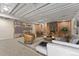 Finished basement with a brick fireplace, open ceiling and cozy seating area at 2692 S Pennsylvania St, Denver, CO 80210