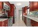 Modern kitchen featuring cherry wood cabinets, stainless appliances, and stone countertops at 2692 S Pennsylvania St, Denver, CO 80210