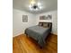 Bedroom features wood floors, natural light, a closet, and decorative wall art at 4995 N Beach Ct, Denver, CO 80221
