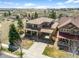 Expansive aerial view of a home with a portico, golf course views, and mature trees at 12119 S Wanderlust Way, Parker, CO 80138