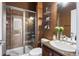 Bathroom featuring a tiled shower, granite counters, and decorative shelving at 12119 S Wanderlust Way, Parker, CO 80138