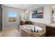 Elegant bathroom featuring double sinks, granite counters, a soaking tub, and natural light from a window at 12119 S Wanderlust Way, Parker, CO 80138