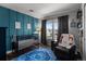 Charming bedroom featuring a blue accent wall, and a comfortable chair at 12119 S Wanderlust Way, Parker, CO 80138