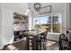 Bright dining area with modern light fixture, brick wall and a large window with outdoor scenery at 12119 S Wanderlust Way, Parker, CO 80138