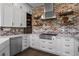 Stylish kitchen with white cabinetry, stainless steel appliances, and a unique brick wall at 12119 S Wanderlust Way, Parker, CO 80138