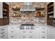 Modern kitchen showcasing stainless steel appliances, white cabinets, and a brick backsplash at 12119 S Wanderlust Way, Parker, CO 80138