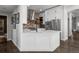 Corner view of kitchen featuring white cabinets, stainless steel appliances, and brick accents at 12119 S Wanderlust Way, Parker, CO 80138