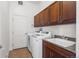 Laundry room with a utility sink, washer, dryer, and plenty of cabinet space at 12119 S Wanderlust Way, Parker, CO 80138