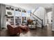 Cozy living room with custom built-ins, a decorative staircase, and stylish furnishings at 12119 S Wanderlust Way, Parker, CO 80138