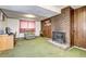 Finished basement with green carpet, wood paneling, and a brick fireplace, perfect for a cozy den at 301 S Troy St, Aurora, CO 80012