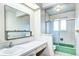 Bathroom featuring a vanity with a mirror and a shower/tub combo with glass doors at 301 S Troy St, Aurora, CO 80012