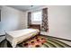Bedroom features a window and closet, and a colorful rug on the floor at 301 S Troy St, Aurora, CO 80012