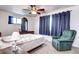 Bedroom featuring neutral carpet, dresser, a ceiling fan, and dual windows at 301 S Troy St, Aurora, CO 80012