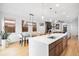 Open-concept kitchen and dining area with a large island, modern lighting, and views of the living space at 3928 Vrain St, Denver, CO 80212