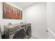 Convenient laundry room features a modern Samsung washer and dryer, complemented by stylish wall art at 3928 Vrain St, Denver, CO 80212