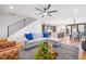 Inviting living room with modern staircase, gray sectional sofa with blue pillows, flowing into dining area and kitchen at 3928 Vrain St, Denver, CO 80212