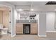 Basement wet bar with cabinets, granite counter, mirror, and beverage cooler at 11300 Night Heron Dr, Parker, CO 80134