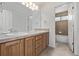 Spacious bathroom with double sinks, wood cabinets, and a separate tiled shower at 11300 Night Heron Dr, Parker, CO 80134