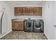 Well-equipped laundry room with wooden cabinets and modern washer and dryer at 11300 Night Heron Dr, Parker, CO 80134