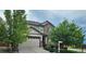 Charming two-story home featuring a two-car garage, beautiful stone accents, and mature trees in the front yard at 22336 E Bellewood Dr, Aurora, CO 80015