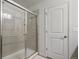 Bathroom with glass shower featuring light tile and updated fixtures at 22336 E Bellewood Dr, Aurora, CO 80015