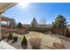 A spacious backyard features wooden planters, a rock bed, and a well-maintained wooden fence at 22336 E Bellewood Dr, Centennial, CO 80015