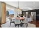 Open dining area with stylish pendant lighting, adjoining modern kitchen with island seating, and a view to the backyard at 22336 E Bellewood Dr, Aurora, CO 80015