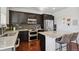 Modern kitchen featuring dark cabinets, stainless steel appliances, and a center island with seating at 22336 E Bellewood Dr, Aurora, CO 80015