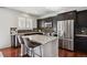 Modern kitchen featuring dark cabinets, stainless steel appliances, and a center island with seating at 22336 E Bellewood Dr, Aurora, CO 80015