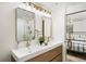 Double vanity bathroom with a walk-in shower, gold fixtures, modern mirrors, and wood cabinets at 9405 W 54Th Pl, Arvada, CO 80002